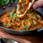 Chicken balti curry served in and iron karahi being eaten with naan bread featuring a title overlay.