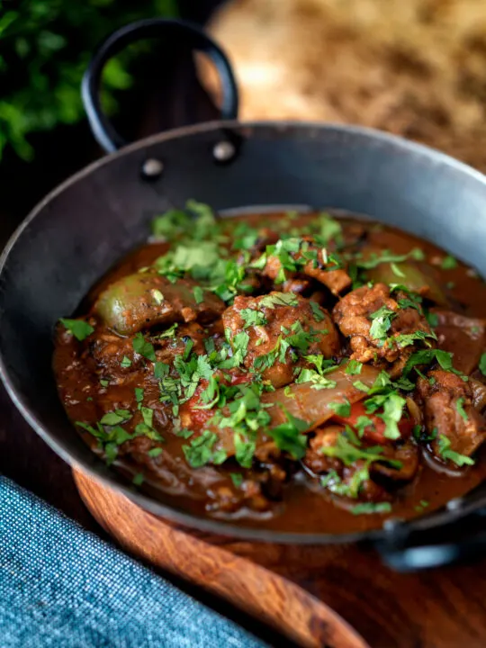 British Indian chicken jalfrezi curry with fresh coriander served in an iron karai.