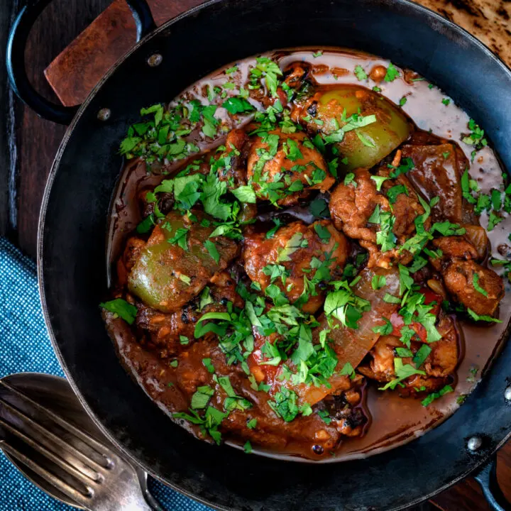 British Indian chicken jalfrezi curry with peppers and fresh coriander served in an iron karai.