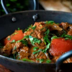 Indian influenced lamb jalfrezi curry garnished with fresh coriander.