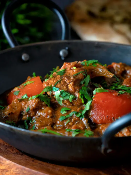 Indian influenced lamb jalfrezi curry garnished with fresh coriander.