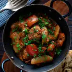 Overhead Indian influenced lamb jalfrezi curry served with a naan bread featuring a title overlay.