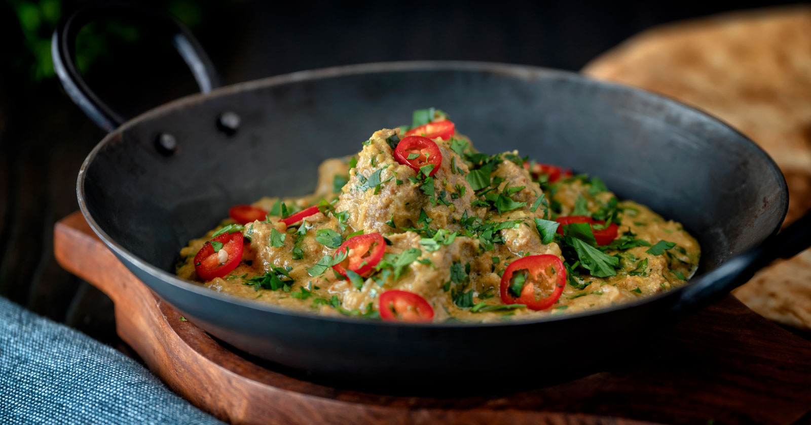 Indian influenced lamb pasanda almond and yoghurt curry garnished with fresh chilli and coriander.