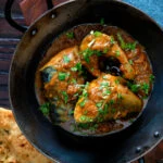 Overhead Indian influenced mackerel curry served in a karai.