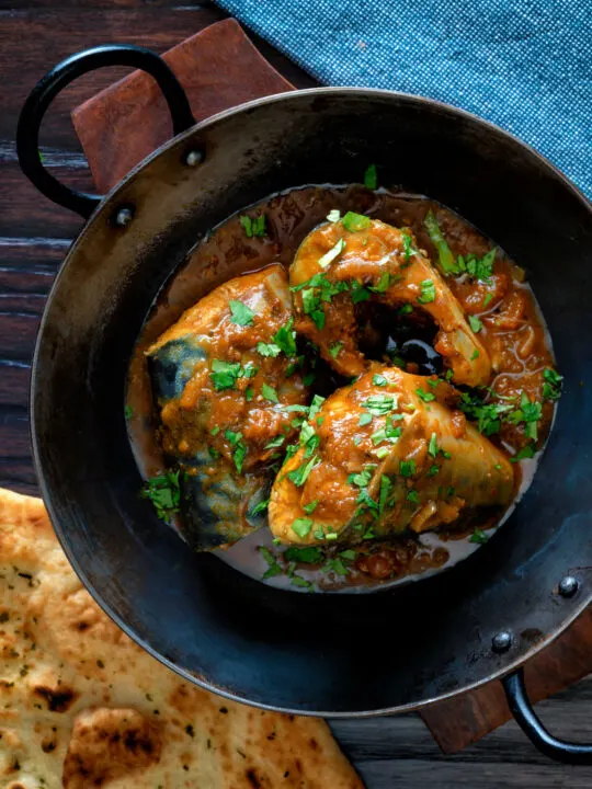 Overhead Indian influenced mackerel curry served in a karai.
