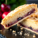 Mini Bakewell tarts cut open to show the frangipane and jam filling.