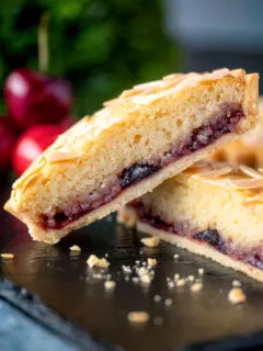 Mini Bakewell tarts cut open to show the frangipane and jam filling.