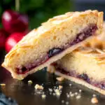 Mini Bakewell tarts cut open to show the frangipane and jam filling featuring a title overlay.