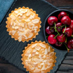 Overhead mini Bakewell tarts with a frangipane filling and almond topping.