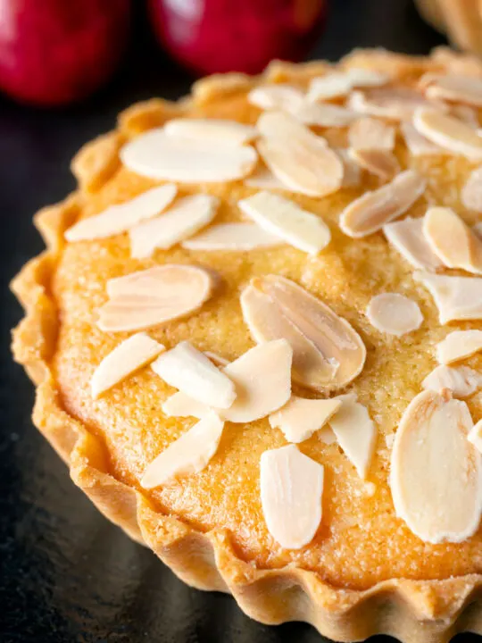 Close up mini Bakewell tarts with a frangipane filling and almond topping.