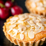 Mini Bakewell tarts with a frangipane filling and almond topping featuring a title overlay.