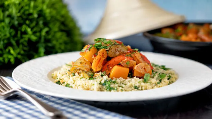 Moroccan influenced vegan vegetable tagine with squash and courgette served with buttered couscous.