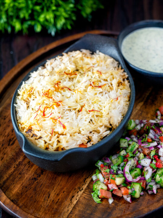 Vegan mushroom biryani served with mint raita and kachumber salad.