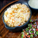 Vegan mushroom biryani served with raita and kachumber salad featuring a title overlay.