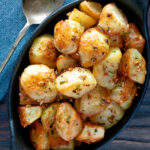 Overhead Parmentier potatoes or mini roast potatoes with rosemary and garlic featuring a title overlay.