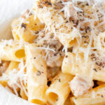 Penne rigatoni alla norcina with black pepper and creamy pork sausage featuring a title overlay.