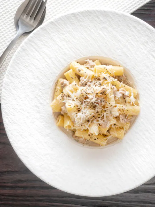 Overhead pasta alla norcina with black pepper and fresh parmesan cheese.