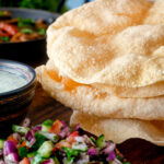 Indian poppadoms or papad served with kachumber salad and mint raita.