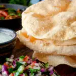 Indian poppadoms or papad served with kachumber salad and mint raita.