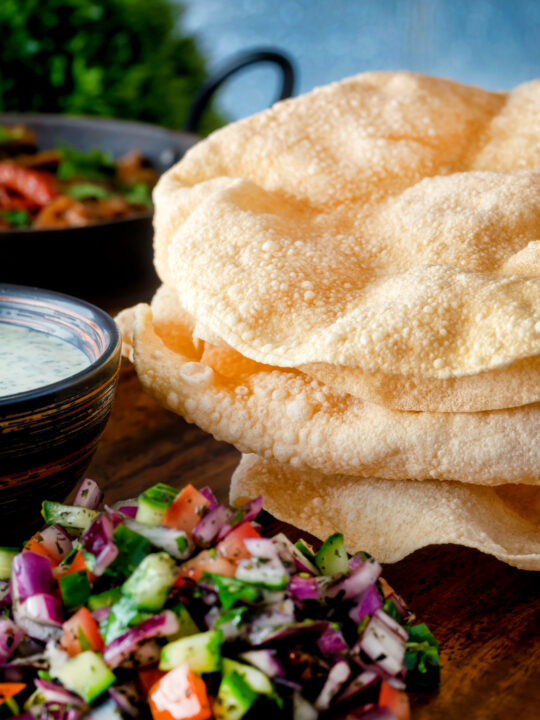 Indian poppadoms or papad served with kachumber salad and mint raita.