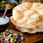 Freshly cooked poppadoms or papad served as part of an Indian spread featuring a title overlay.