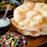 Freshly cooked poppadoms or papad served as part of an Indian spread featuring a title overlay.