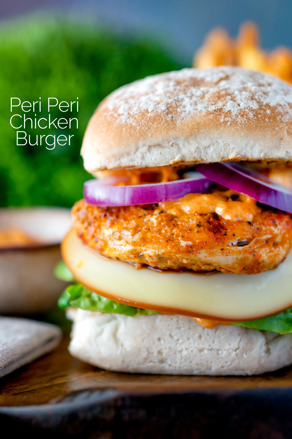 Peri peri chicken burger served with red onion and smoked cheese featuring a title overlay.