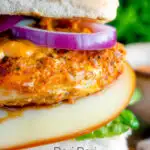 Close up peri peri chicken burger served with red onion and smoked cheese featuring a title overlay.