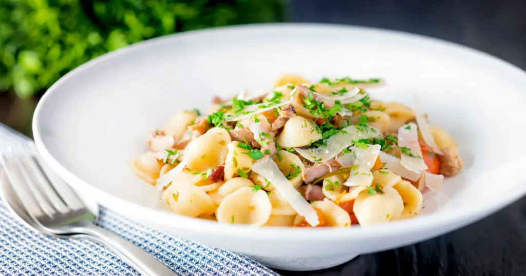 Braised rabbit ragu served with orecchiette pasta and fresh parsley and parmesan shavings.