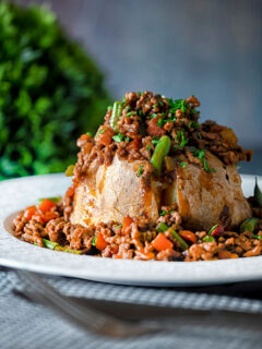 Savoury minced beef with green beans served over a jacket potato.