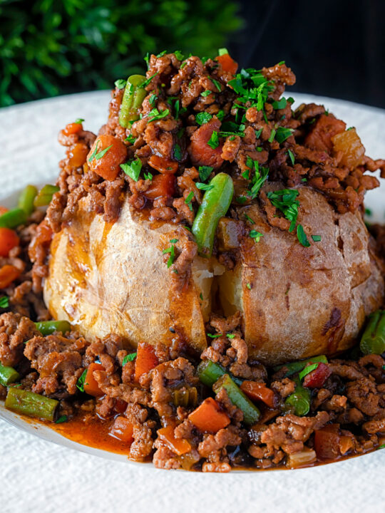 Savoury minced beef with green beans served over a jacket potato.