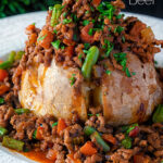 Close up savoury minced beef with green beans served over a jacket potato featuring a title overlay.