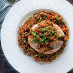 Overhead savoury minced beef with green beans served over a jacket potato.
