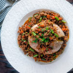 Overhead savoury minced beef with green beans served over a jacket potato featuring a title overlay.