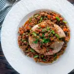 Overhead savoury minced beef with green beans served over a jacket potato featuring a title overlay.