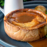 Traditional Scotch meat pie served with lamb gravy featuring a title overlay.