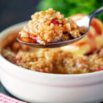 Individual strawberry crumble with balsamic vinegar on a spoon.