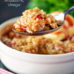 Individual strawberry crumble with balsamic vinegar on a spoon.