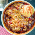 Overhead individual strawberry crumble with balsamic vinegar served with vanilla ice cream featuring a title overlay.