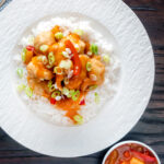 Overhead Chinese takeaway style crispy fried sweet and sour chicken balls.