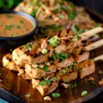 Tofu satay with a peanut sauce and noodle salad featuring a title overlay.