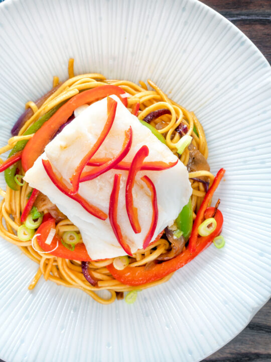Overhead cod loin cooked en papillote served with sweet chilli noodles.