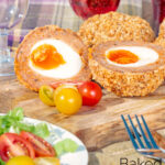 Oven baked scotch eggs cut open to show a jammy yolk featuring a title overlay.