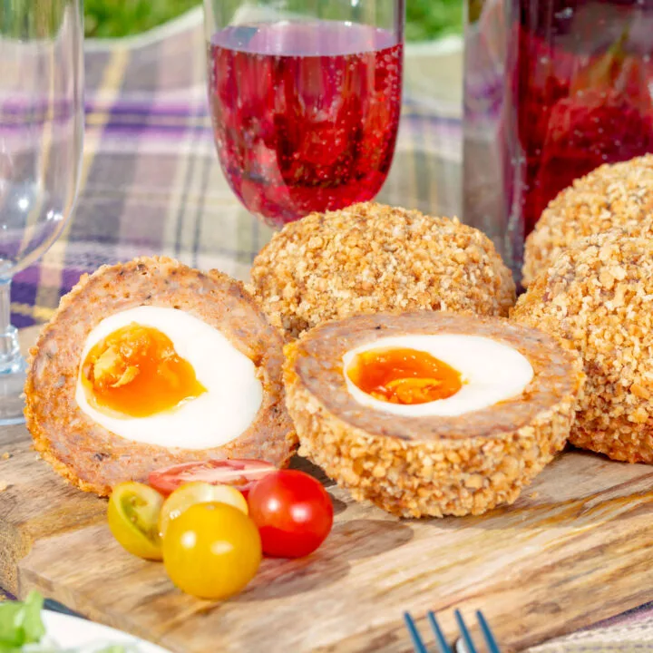 Oven baked perfect Scotch eggs as part of a picnic spread.