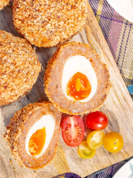 Close up overhead oven baked Scotch eggs with cherry tomatoes.