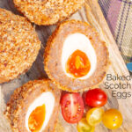 Close up overhead oven baked Scotch eggs with cherry tomatoes featuring a title overlay.