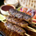 Minced beef kofta kebabs served with salad, pita bread and sauces.