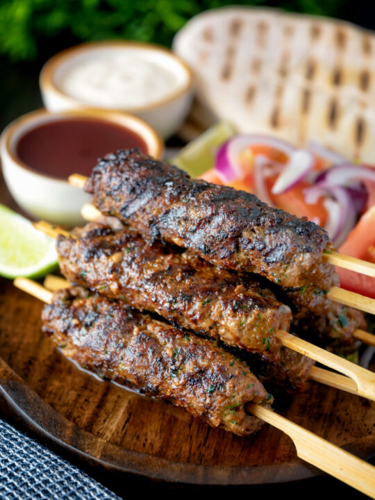 Minced beef kofta kebabs served with salad, pita bread and sauces.