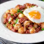 Canned corned beef hash with fried egg and peas featuring a title overlay.