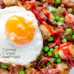 Close up overhead canned corned beef hash with fried egg and peas and ketchup featuring a title overlay.